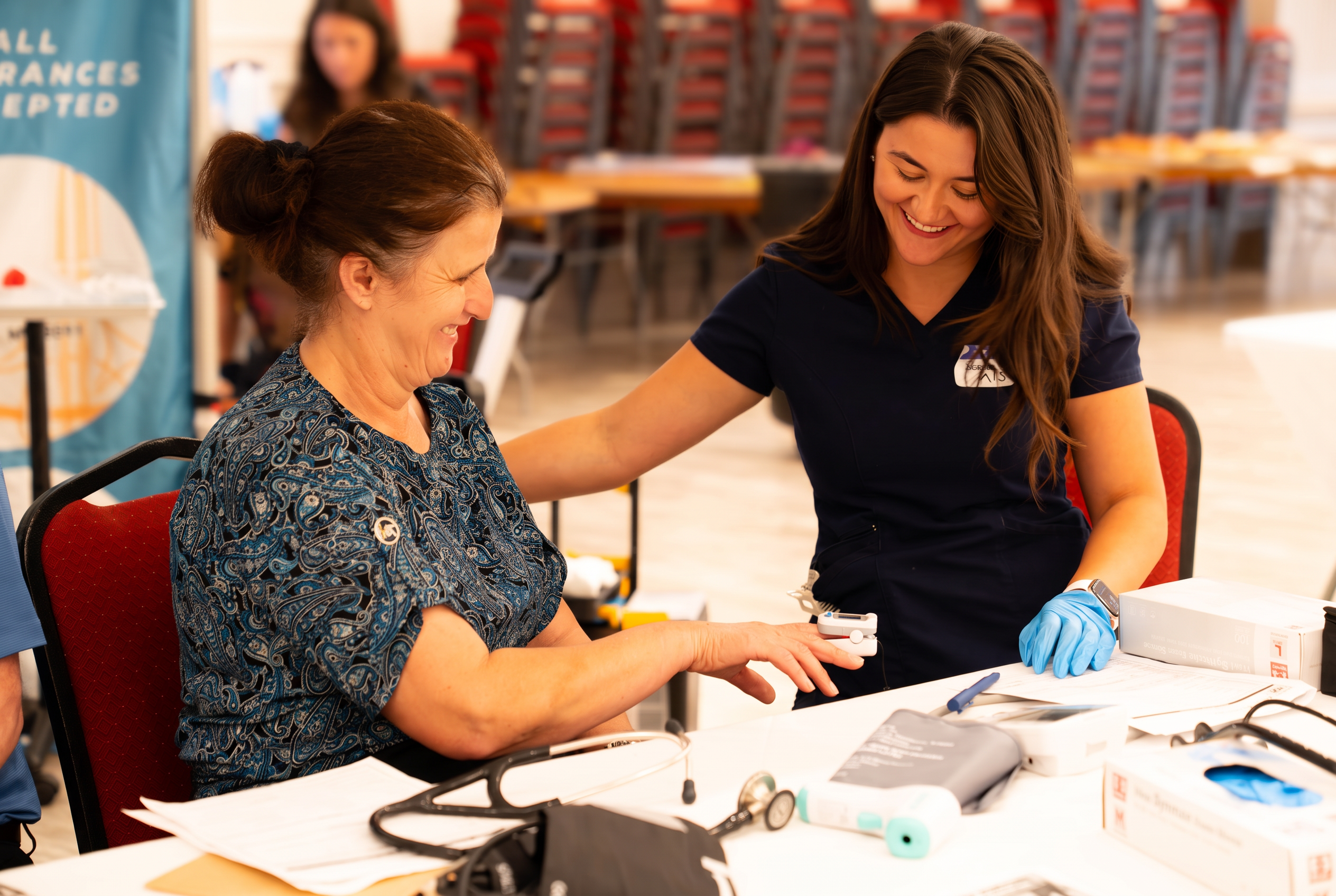 A nurse checking a community member's pulse at the AAMMO Health Fair